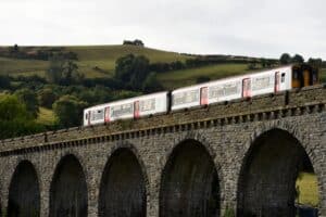A two-carriage train crossing the Knucklas Viaduct, Mid Wales