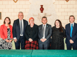 Three men and three women standing in a row, smiling